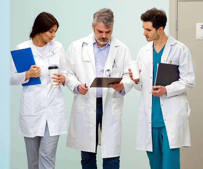 Tres médicos consultando una historia clínica de un paciente