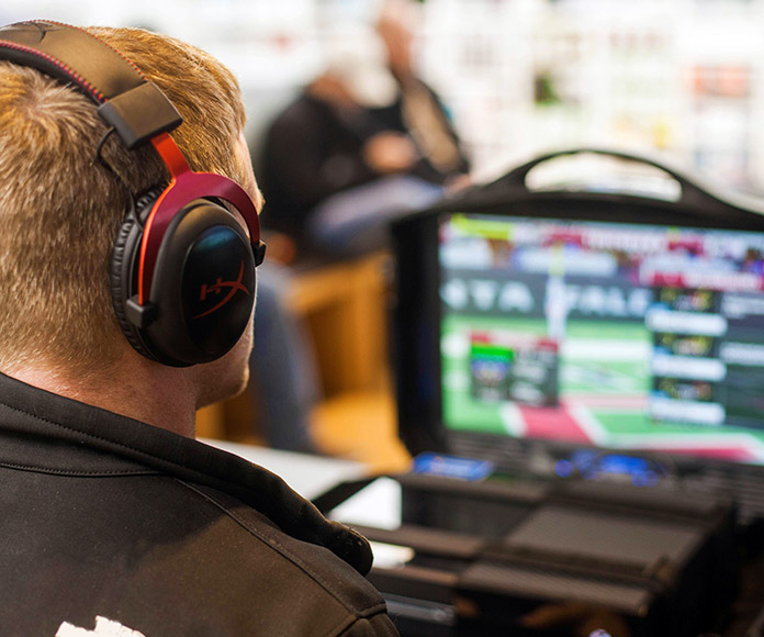 Hombre con auriculares mirando un monitor de datos deportivos