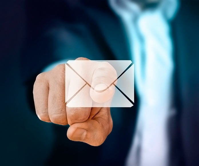 Hombre trajeado pulsando un icono de email iluminado