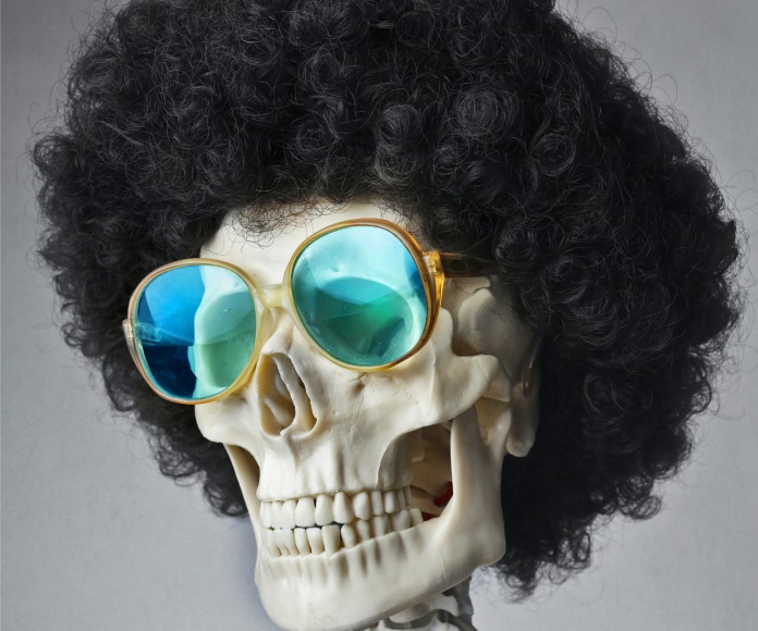 Esqueleto humano con una peluca y lentes puestos
