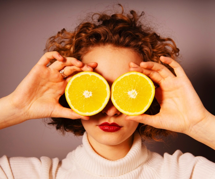 Mujer con dos limones en su rostro.