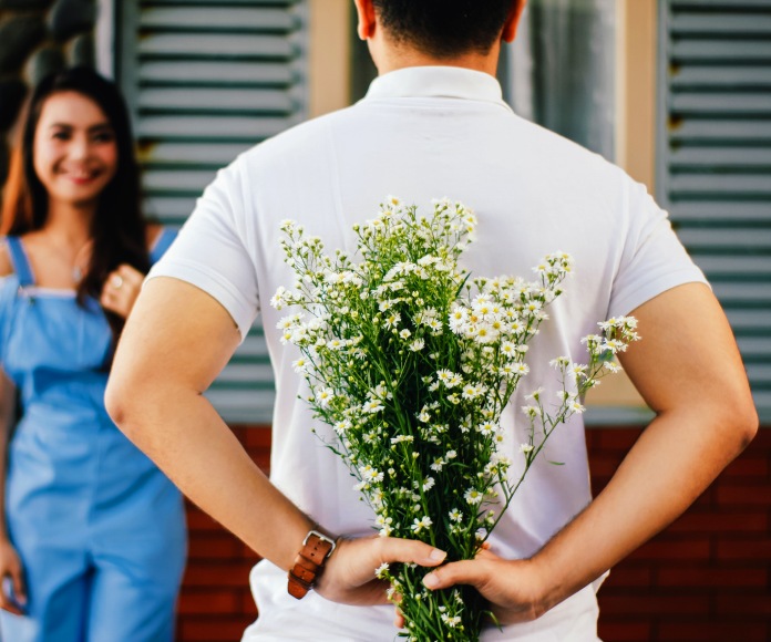 Hombre con ramo de flores en la espalda.