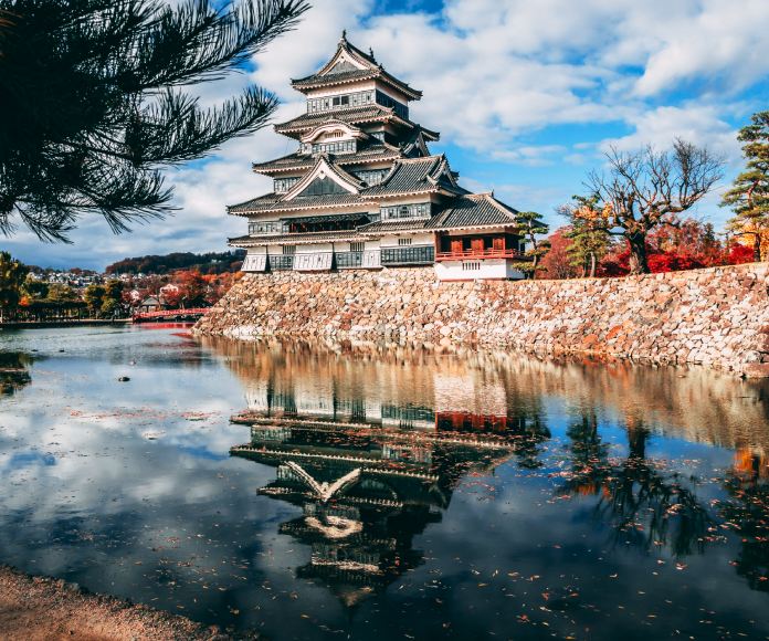 Un templo japonés sobre una saliente de tierra a orillas de un cuerpo de agua.