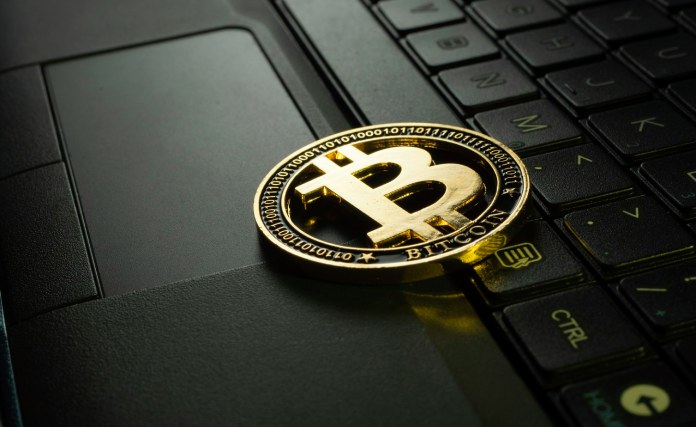 Ordenador y simbolo de bitcoin.