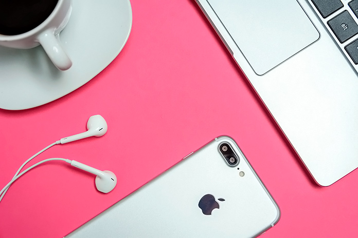 iPhone, MacBook y earphones en una mesa