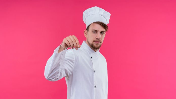 chef joven salando un plato