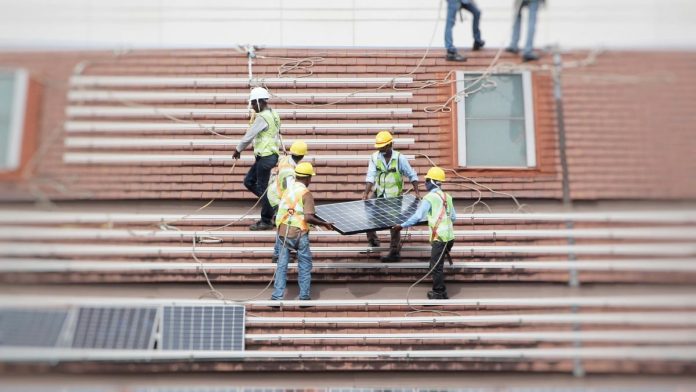 Obreros sosteniendo un módulo fotovoltaicos