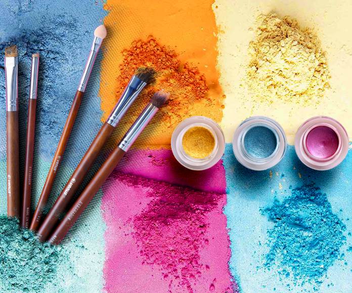 Pinceles, sombras y polvos de maquillaje de colores vivos