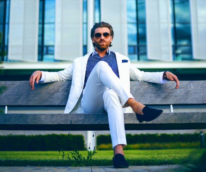 Hombre elegante sentado en un banco.