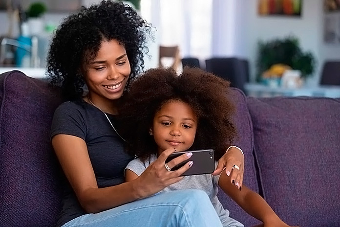 madre e hija viendo juntas algo en el móvil