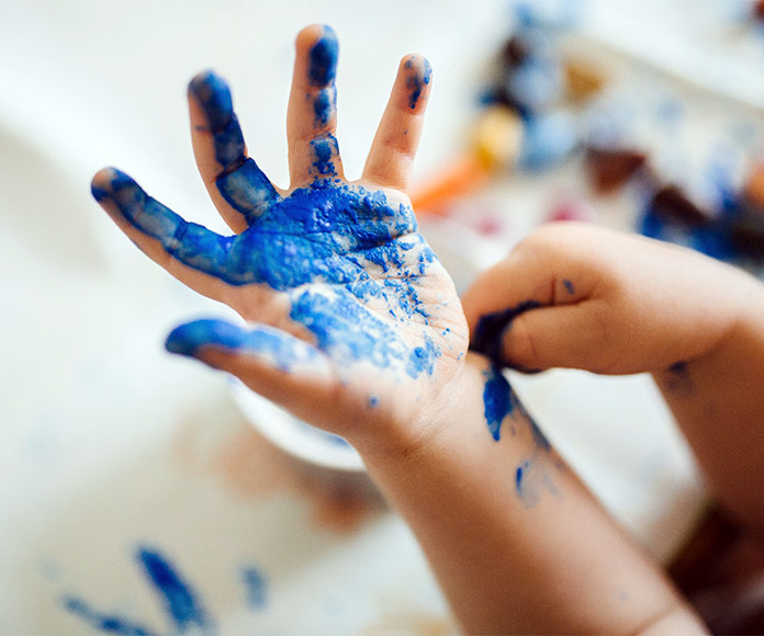 Mano de niño con pintura azul