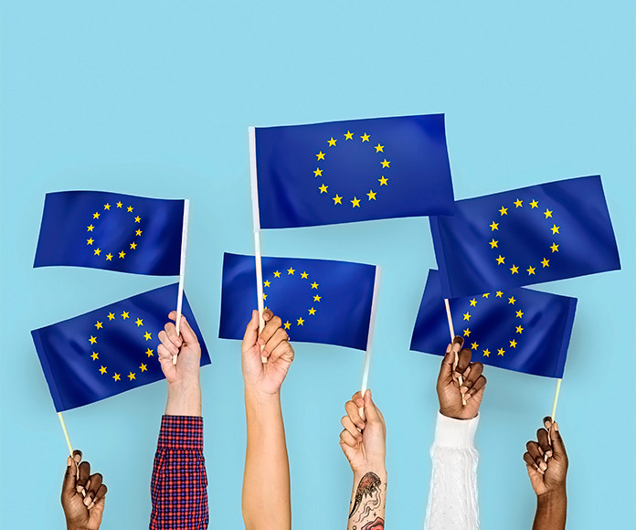 manos sujetando banderas de Europa