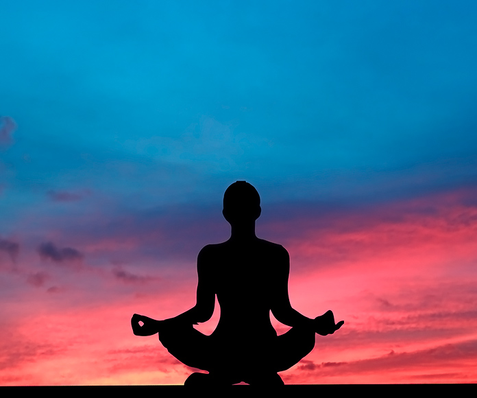 silueta de persona meditando al atardecer