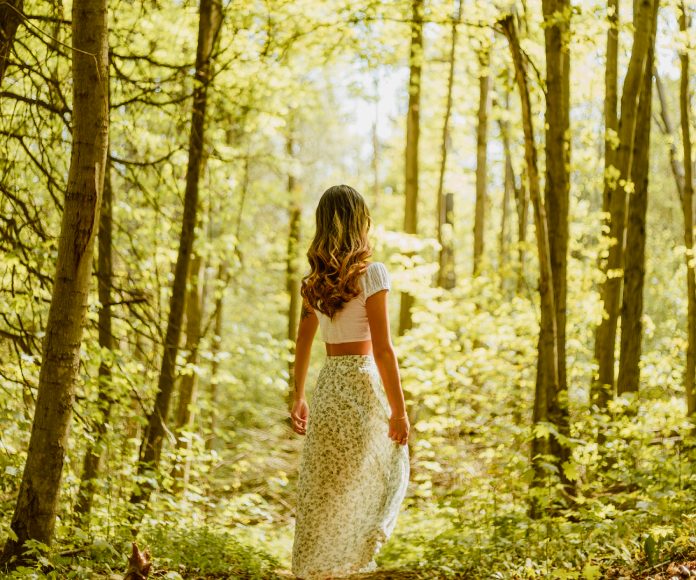 Mujer con vestido en medio de un bosque.