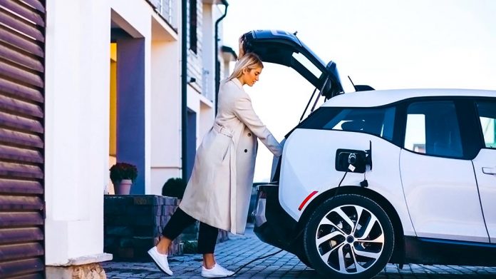 mujer cargando un vehículo eléctrico