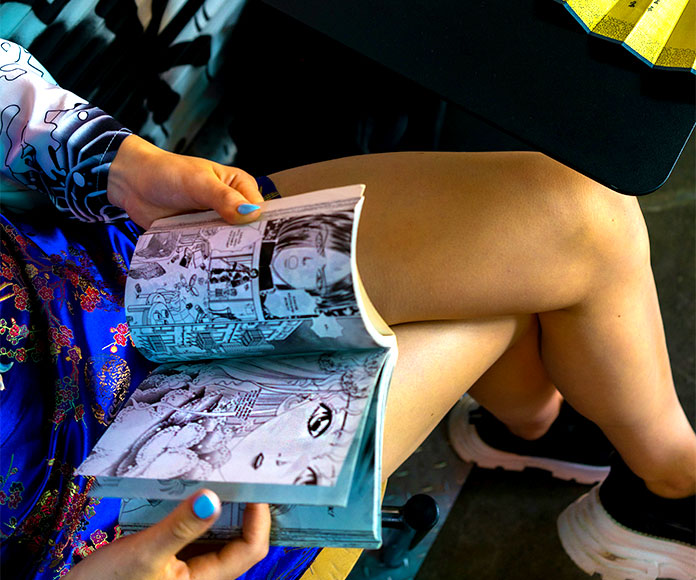 Mujer sentada leyendo un comic manga.