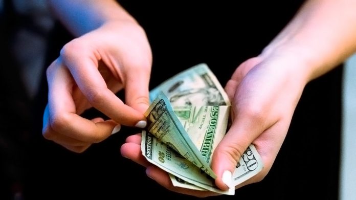 Manos de mujer contando dinero
