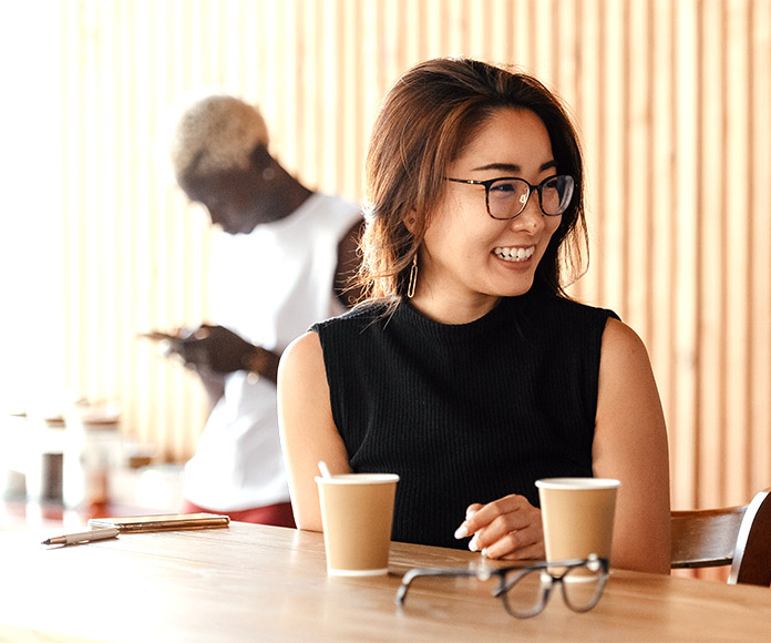 Mujer sonriente en descanso laboral tomando un café