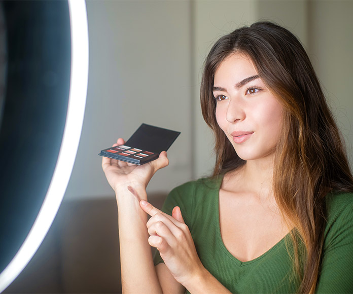 Mujer influencer probando maquillajes frente a cámara
