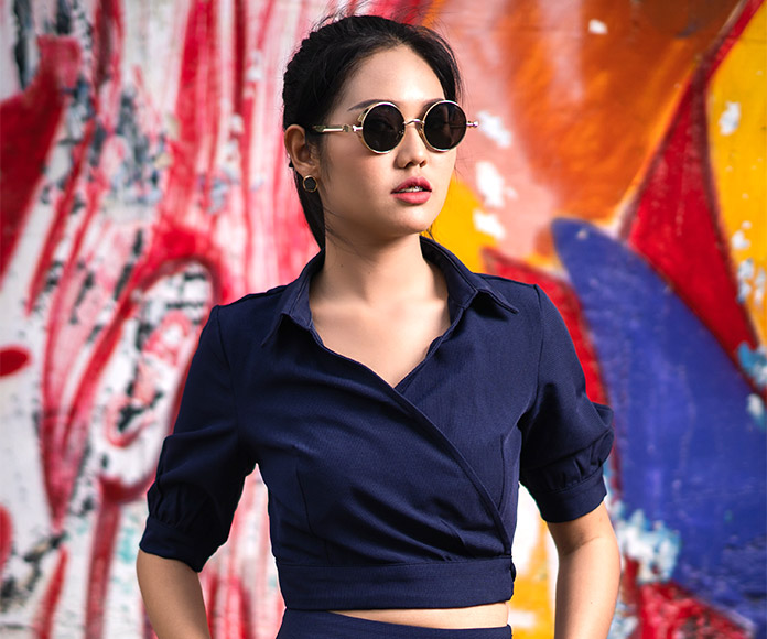 Mujer modelo posando con ropa azul marino y gafas de sol