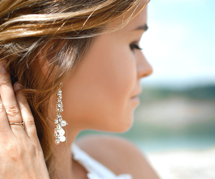 Mujer mostrando un pendiente de perlas
