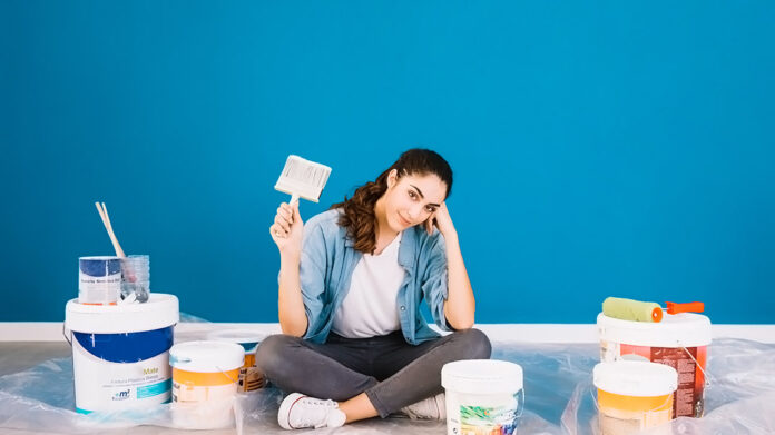 mujer pintando su casa