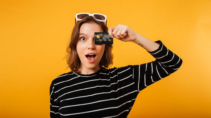 Chica tapándose un ojo con una tarjeta de crédito