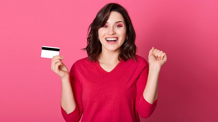 mujer sujetando tarjeta de crédito