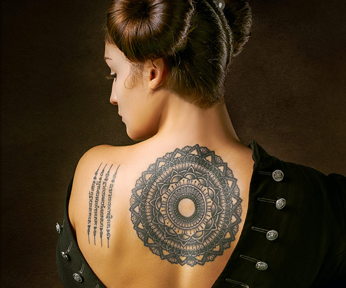 Mujer mostrando tatuaje en la espalda