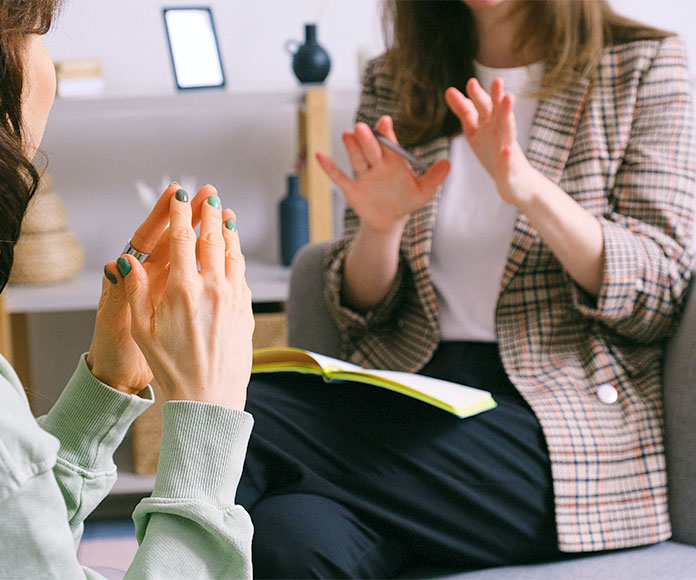 Dos mujeres sentadas en entrevista o en consulta de psicóloga