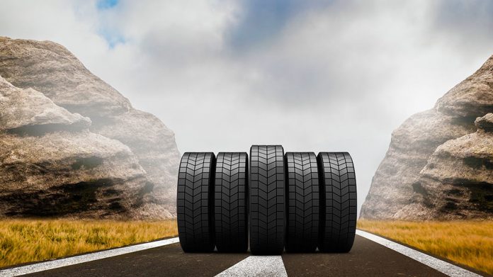 neumáticos rodando por una carretera rodeada de rocas