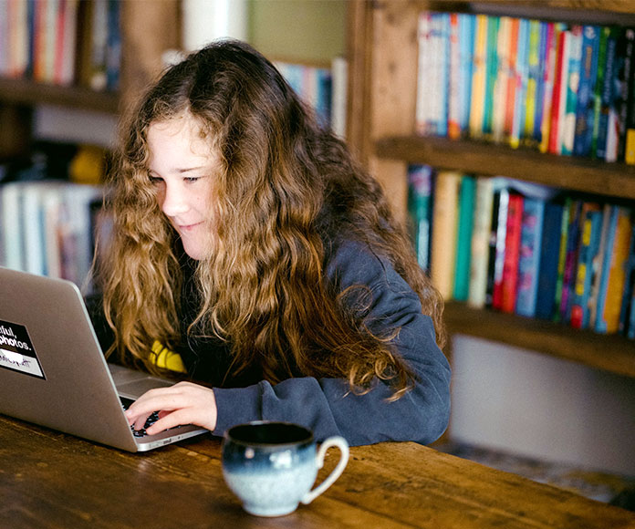 Niña estudiando frente a un ordenador