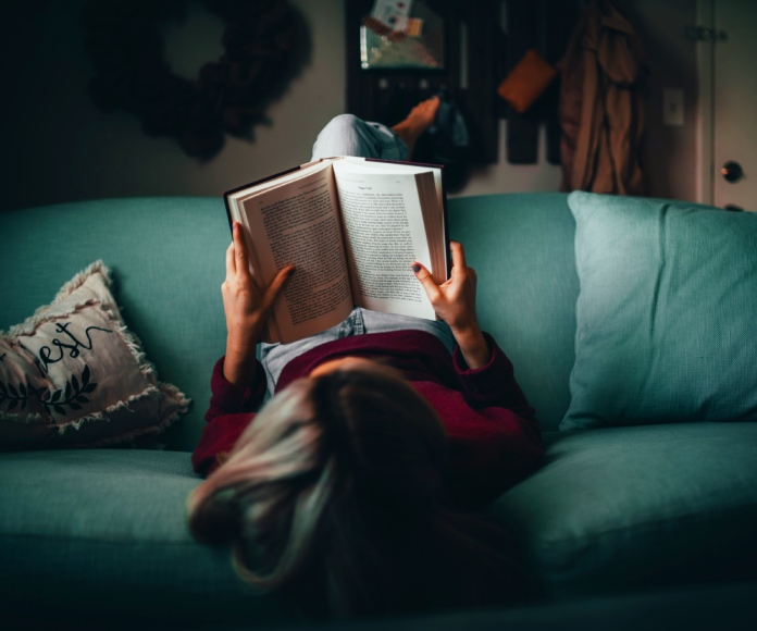 Mujer leyendo en un sofá.
