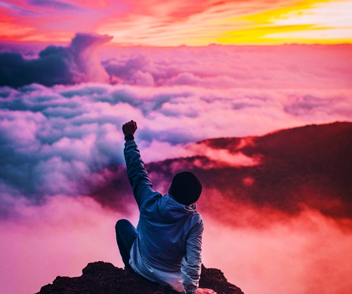 Persona en una cima sobre las nubes.