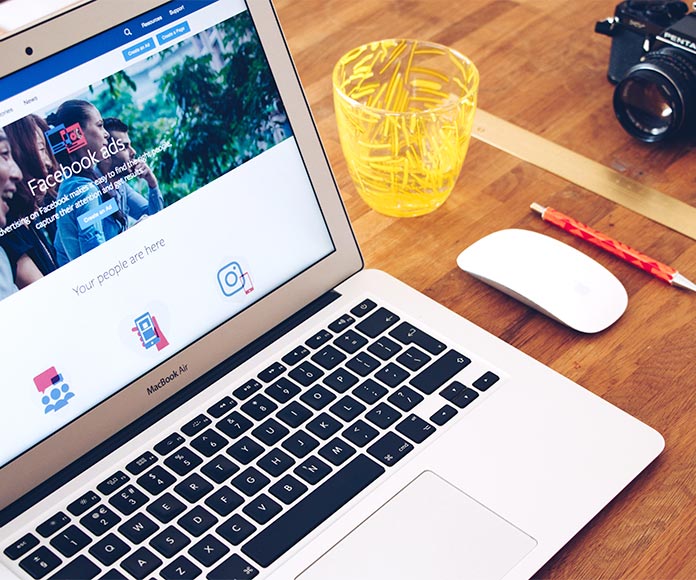 Ordenador portátil con Facebook Ads en la pantalla (publicidad digital)