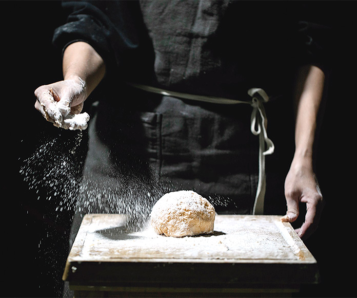 Panadero amasando pan con harina