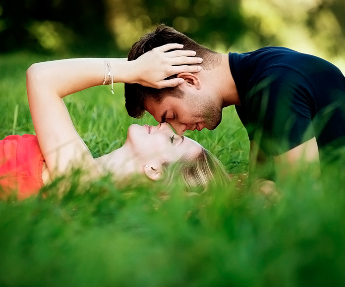 pareja de enamorados besándose sobre la hierba