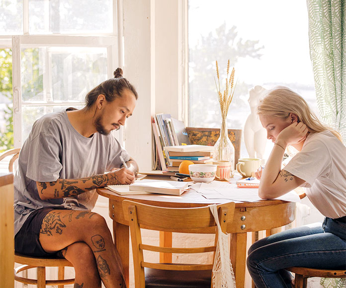 Pareja estudiando en la mesa de comedor