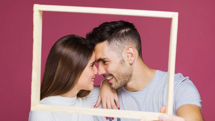 pareja feliz sujetando un marco