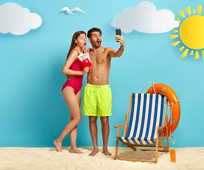 pareja haciéndose un selfie en un decorado que simula la playa