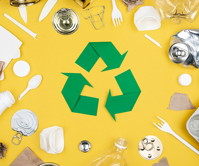 plásticos y envases rodeando el símbolo de reciclaje sobre un fondo amarillo