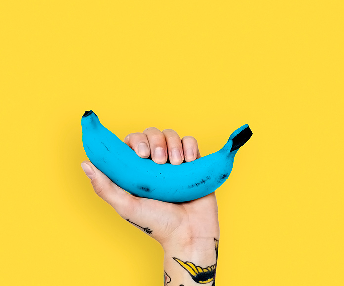 mano tatuada sujetando un plátano azul