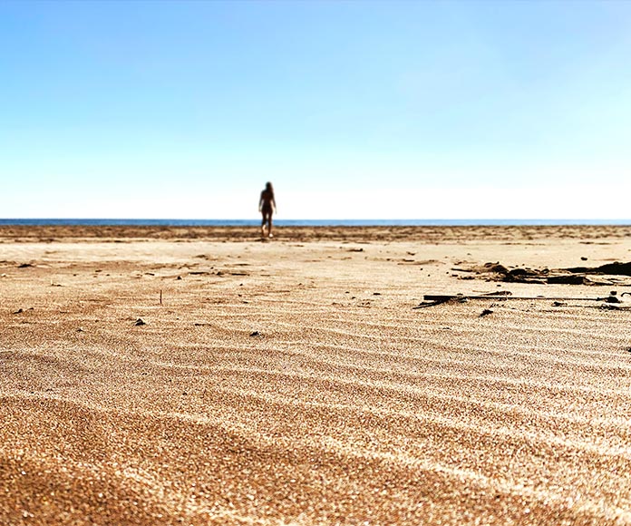 Mujer caminando en una playa en San José, Almería, España