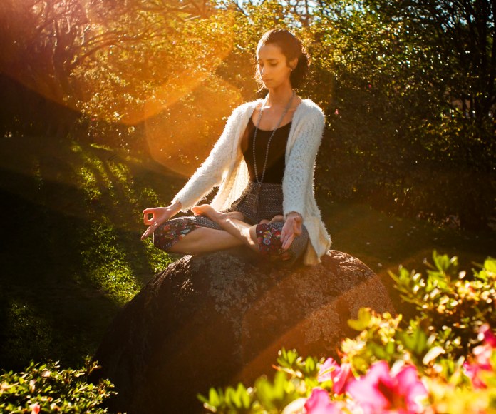 Mujer meditando al aire libre.