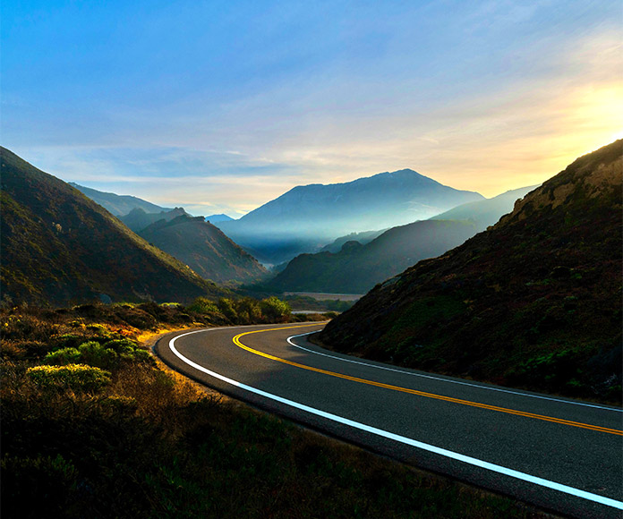 Carretera hacia unas montañas en día soleado