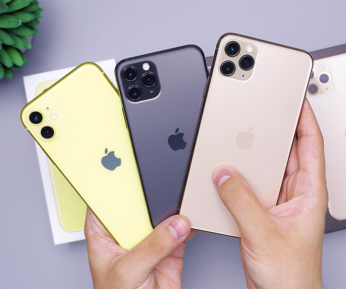 Manos mostrando tres teléfonos modernos de iPhone