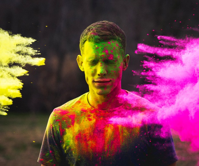 Persona siendo pintada con gases de colores.