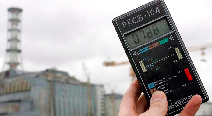Contador Geiger que mide la radiactividad frente al sarcófago de Chernóbil