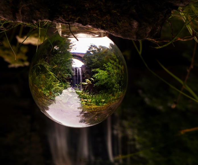 Gota de roció reflejando un paisaje.