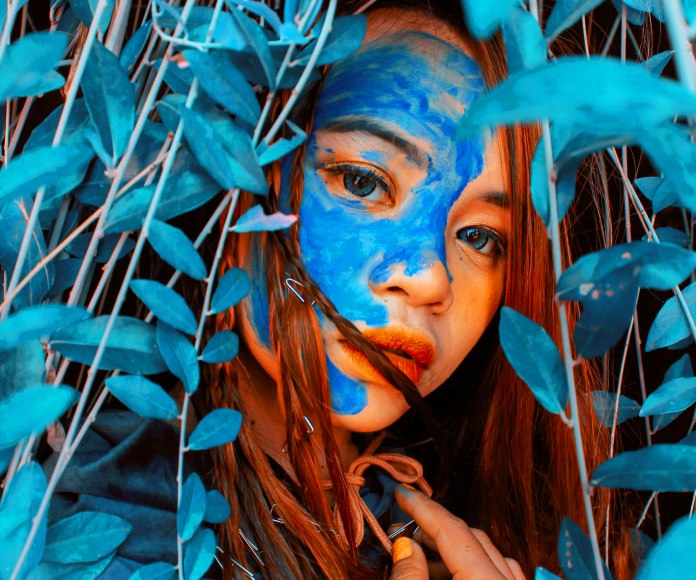 Chica asiática entre hojas azules.